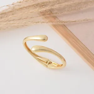 Detailed close-up view of the golden teardrop spring cuff bracelet showcased in nice setting.