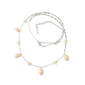 Closeup details of the beach shell waist chain, featuring delicate beads and metal clasp.