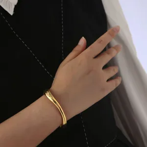 Gold-plated wave cuff bracelet, minimalist organic metal open bangle for daily wear.