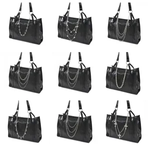 Sac cabas noir élégant en cuir PU avec diverses chaînes en métal et accessoires croisés.