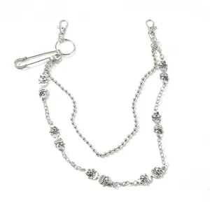 Detailed view of punk silver skull chain with safety pin, perfect for edgy streetwear fashion.