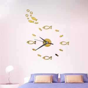 Gold acrylic fish wall clock detail view showing mirror fish stickers and modern hands.