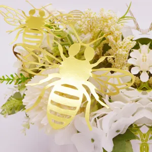 Detailed close-up view of gold 3d hollow bee wall stickers placed on elegant white flowers.