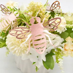 Close-up of 3D hollow rose gold bee wall stickers used for wedding and home decor details.