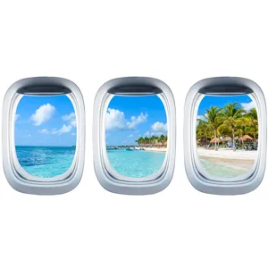 Dettaglio dell'adesivo murale oblò aereo con vivida vista sulla spiaggia tropicale e sul mare.