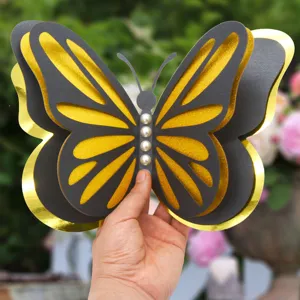 Detailed view of 3D layered butterfly wall sticker with hollow gold and black design and pearls.