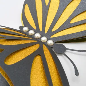 Detailed close-up of 3D hollow butterfly wall sticker with pearl decor and gold glitter layers.
