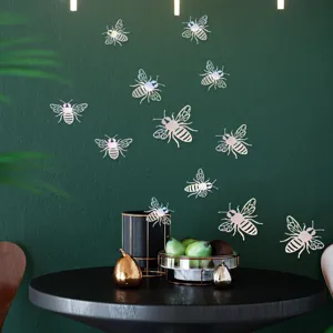 Detailed view of shiny holographic 3D bee wall stickers applied on dark green accent wall.
