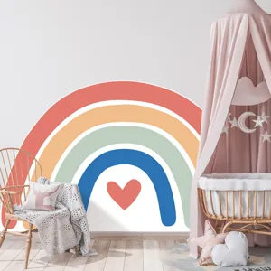 Cozy nursery wall detail featuring large boho rainbow sticker and baby crib decor.
