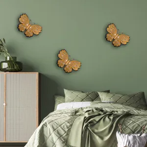 Detailed view of 3D hollow butterfly wall stickers creating elegant gold decor on green wall.