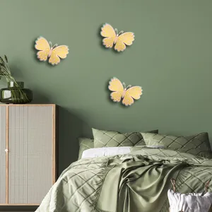 Close-up of 3D layered hollow butterfly wall stickers decorating a green bedroom wall.