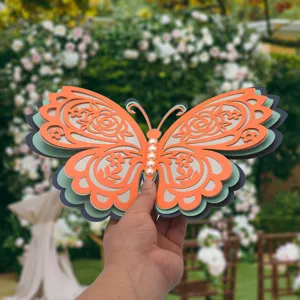 Closeup of 3D layered butterfly paper decor with pearl beads and intricate hollow floral patterns.