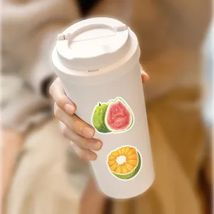Close-up detail of cute fruit stickers featuring guava and citrus on a white cup.