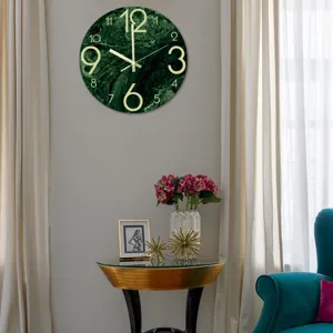 Detalle de escena del reloj de pared de mármol verde montado en la pared de la sala con mesa.