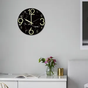 Close-up van stijlvolle lichtgevende marmeren patroon wandklok hangend aan de muur in moderne inrichting.
