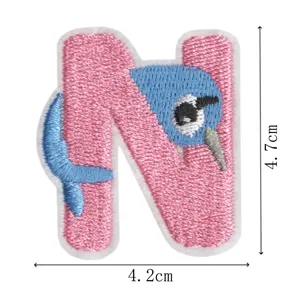 Detail view of the pink and blue letter N animal embroidery patch showing fine stitch texture.