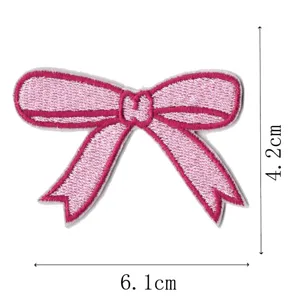 Detailed close-up shot of a cute pink bow embroidery cloth patch, showing fine stitching.