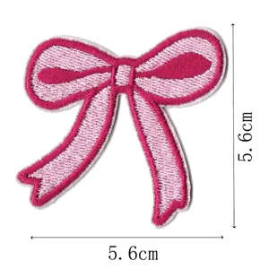 Pink bow embroidery patch detail shot, delicate stitching texture, DIY accessories close up.