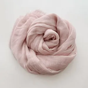 Vista dettagliata di una sciarpa lunga donna in cotone e lino tinta unita rosa tenue.