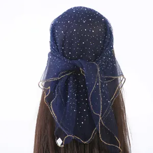 Detailopname van donkerblauwe strass-hoofddoek, sprankelende vierkante sluier met gouden rand.