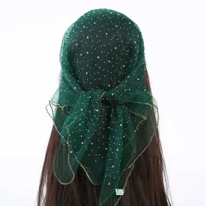 Gedetailleerd uitzicht van donkergroene mesh hoofddoek met strass-steentjes en gouden rand.