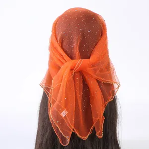 Detailopname van de oranje tule hoofddoek met strass, met schitterende kristaldetails en stof.