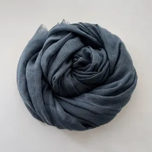 Dettaglio di una sciarpa lunga tinta unita in cotone lino grigio scuro, stile retro autunno.