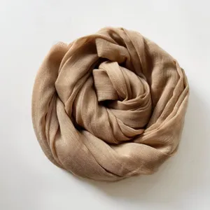 Dettaglio di una elegante sciarpa in lino e cotone beige unito, morbida e raffinata.