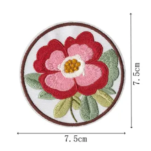 Detailed view of the round embroidered floral patch with vibrant red and pink petals.