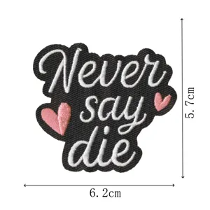 Schwarzer Stickerei Aufnäher mit englischem Text Never say die und rosa Herz Motiven.