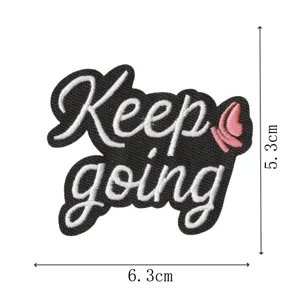 Schwarzer englischer Stickaufnäher mit inspirierenden Buchstaben und rosa Schmetterling für Kleidung.