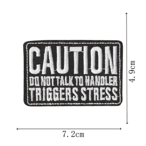Tactical embroidered patch with caution text, black and white DIY clothing accessory badge.