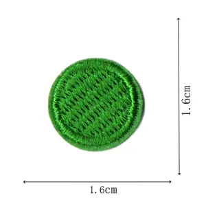 Detail of round green embroidered patch badge with dog tooth lace border, size 1.6cm.