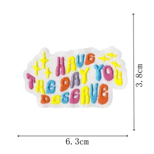 Detailed view of colorful embroidered fabric patch with positive slogan and size guides.