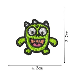 Primer plano de parche bordado de monstruo verde divertido para ropa y accesorios.