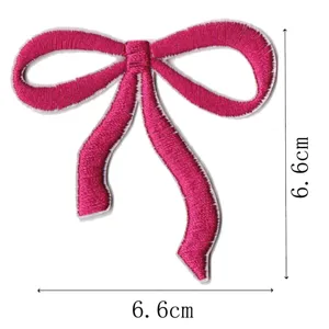 Close-up detail of a pink embroidered bow patch, showing fine stitching texture and clear size.