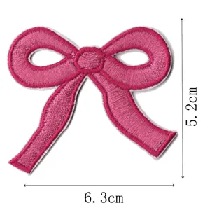 Close-up detail of the pink embroidered bow patch, showing fine stitching and dimensions.