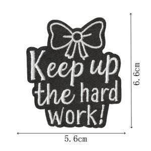 Parche bordado negro con diseño de lazo y frase motivadora para decorar ropa.