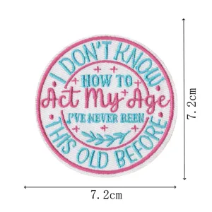 Detail view of a round embroidered patch featuring inspirational English text and leaf motifs.