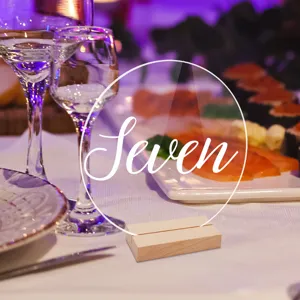 Detalle de tarjeta de numero de mesa redonda de acrilico con base de madera para bodas.