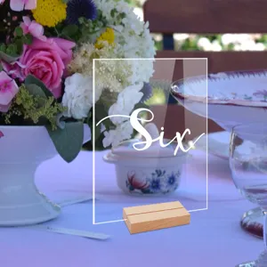 Tarjeta de número de mesa de acrílico transparente con base de madera, ideal para bodas y banquetes.