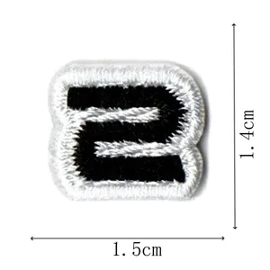 Close-up detail shot of a black and white embroidered number 2 patch, compact size.