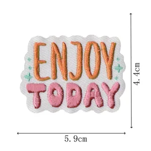 Detailansicht des bestickten Aufnähers mit bunten Enjoy Today Buchstaben und Sternen.