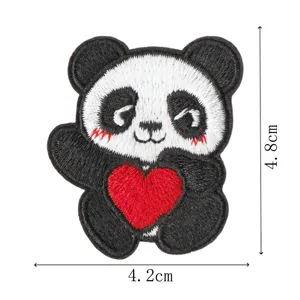 Dettaglio patch ricamata con panda carino che mostra delicate cuciture bianche e nere e un cuore rosso.