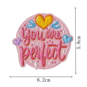 Nahaufnahme eines runden, rosa bestickten Aufnähers mit You are perfect Text und Herzen.