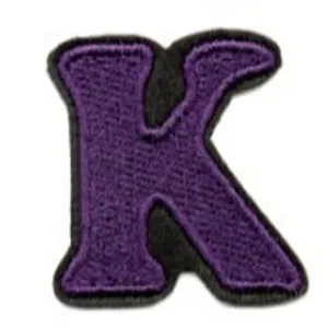 Closeup of purple embroidered letter K patch for clothing DIY decoration and repair.