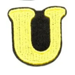 Embroidered letter U patch detail shot, yellow and black color cloth badge accessory.
