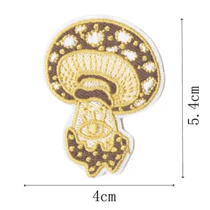 Detailed view of embroidered mushroom patch with eye design, precision stitching, compact size.