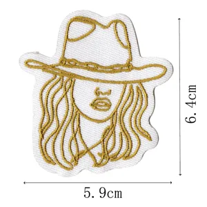 Vista dettagliata della patch ricamata cowgirl, con motivo dorato e bordo in tessuto bianco.