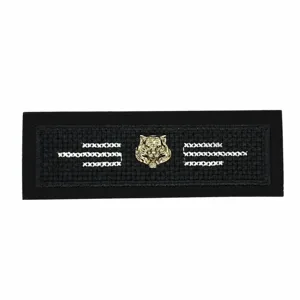 Vue rapprochée du patch brodé noir avec tête de tigre dorée et coutures blanches nettes.